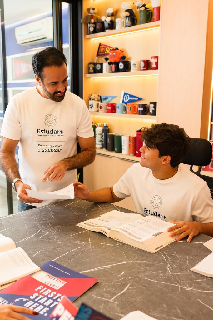 Orientador educacional da Estudar+ prestando atendimento presencial e orientando estudante sobre processo seletivo para universidades americanas